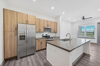 A modern kitchen with wooden cabinets and stainless steel appliances.
